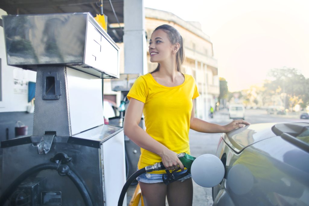 woman in yellow shirt pumping gas