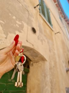 The home buying process in Italy - keys in front of townhouse