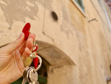 The home buying process in Italy - keys in front of townhouse